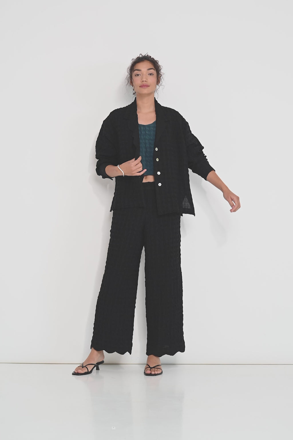 Voyage Pants black linen-viscose seersucker straight-leg pants with scalloped hem, elastic waistband and pockets, made in Canada.